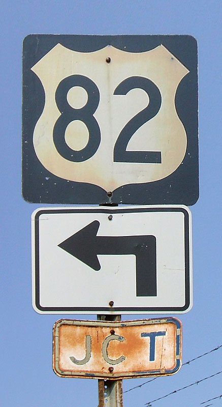 1960s steel US-82 shield, and even older embossed JCT banner. When first put up, this gantry had the JCT banner and a 16" or 21" cutout US-82 shield. The cutout 82 was replaced by the 82 shield shown here, and when the bypass was built, the arrow was added, and the JCT plate moved around, even though it was technically rendered incorrect.